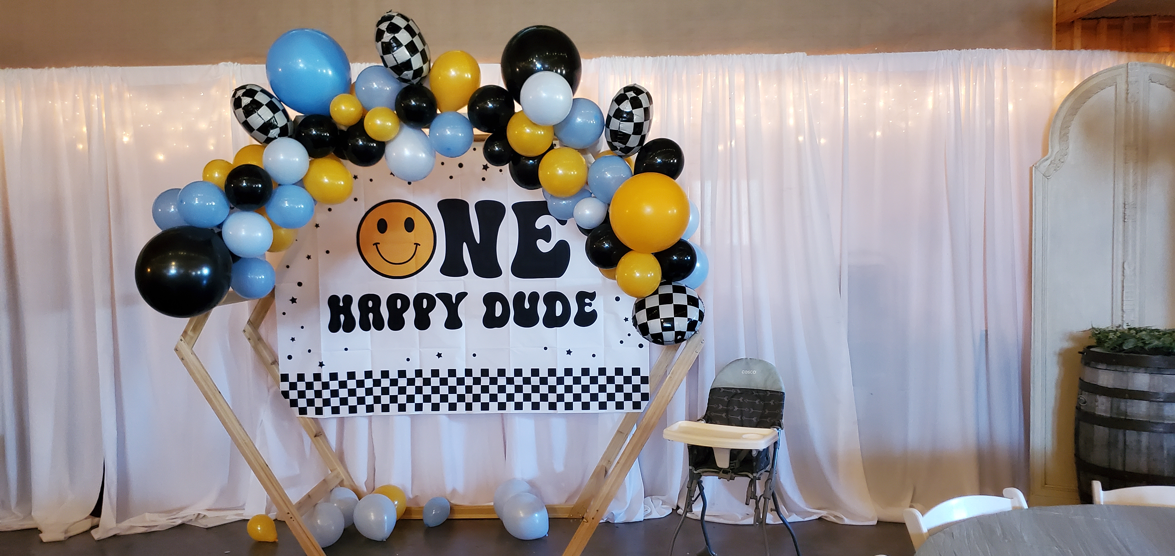 one happy dude themed photo backdrop with balloon arch