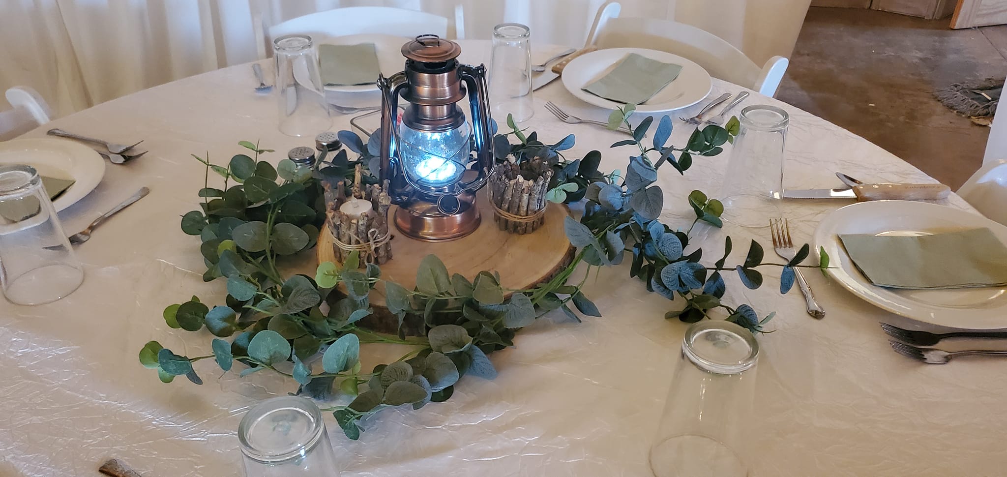 table centerpiece with lantern and greenery