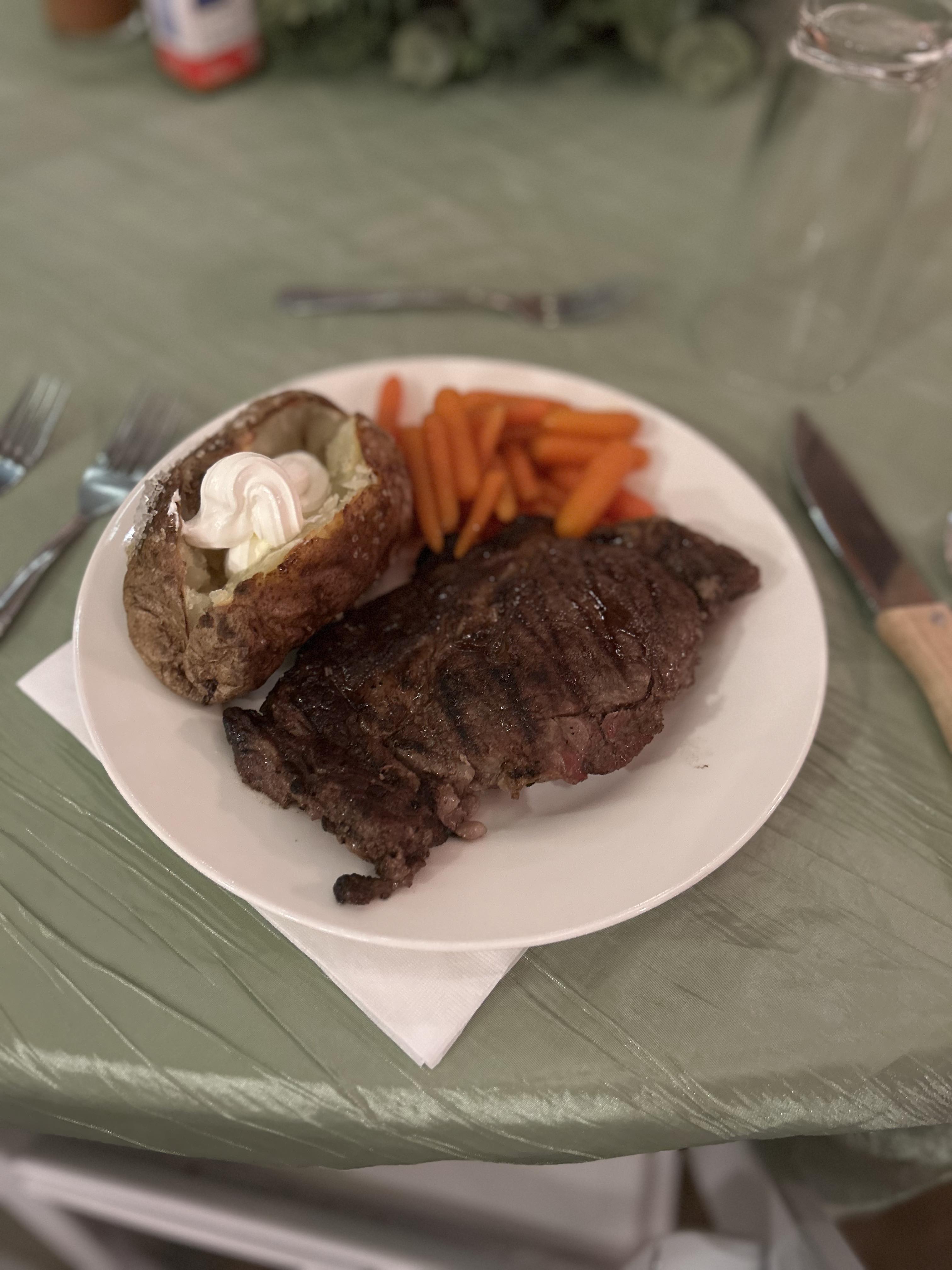steak, baked potato, and roasted carrots